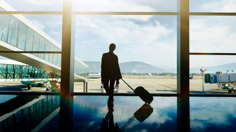 A traveler waits at the airport with luggage in this undated stock photo.