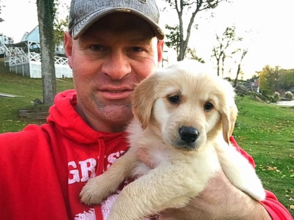 PHOTO: Troy Rogers poses with Clementine, a puppy that was a gift from his high school students.