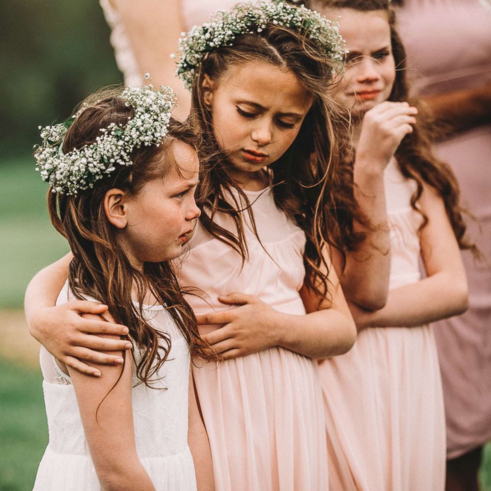 PHOTO: Riley Gibson, 8, comforts her sister Lexi, 6, on May 12 at their parents' wedding in Iowa.