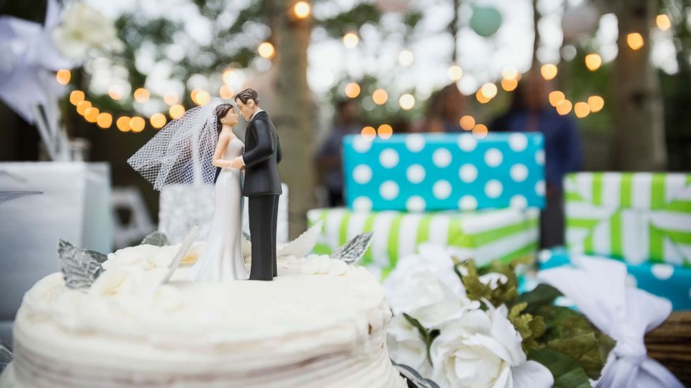 A bride and groom cake topper is pictured on a cake in this undated stock photo.