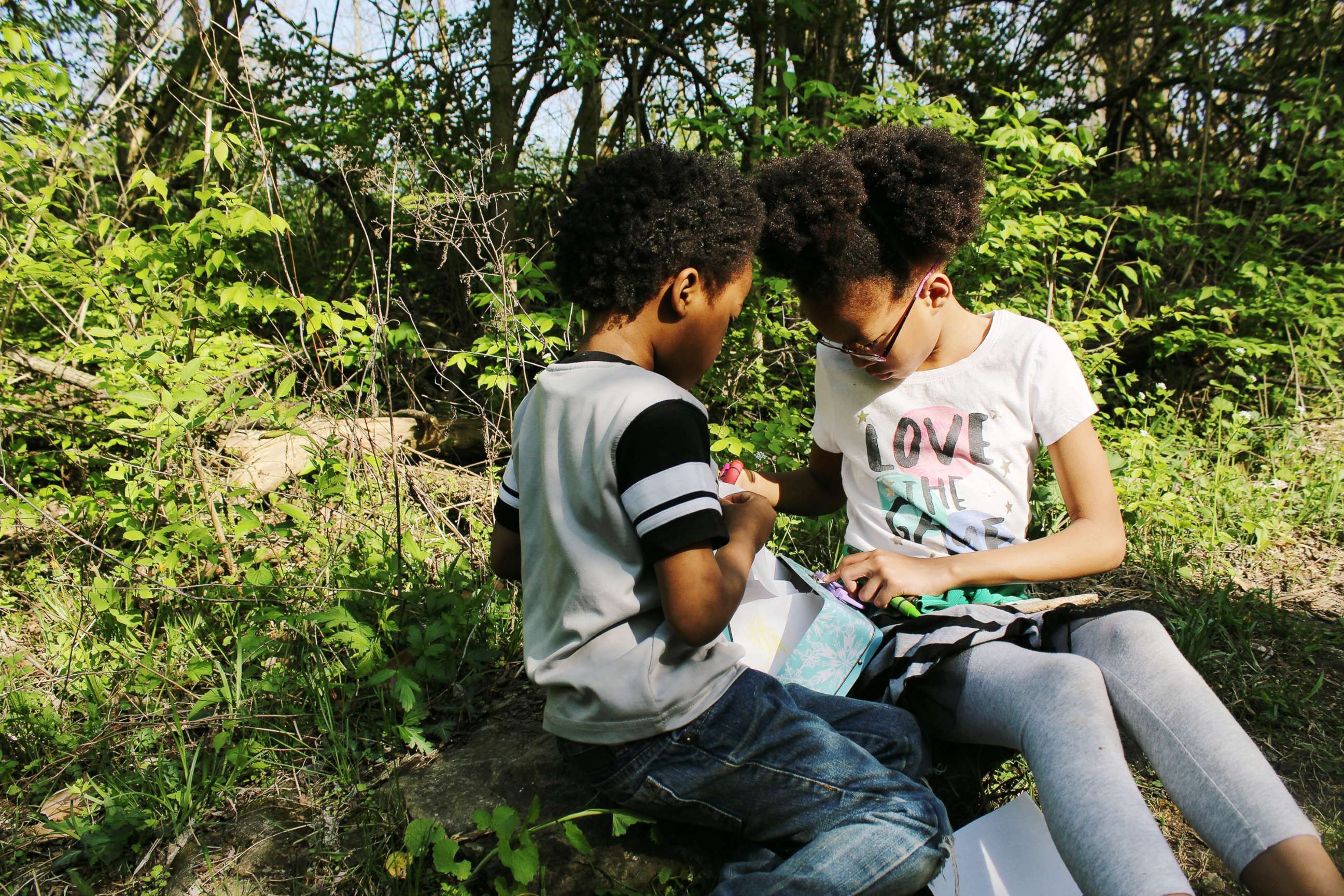 PHOTO: Samuel White, 7, and Ava White, 10, study together in the outdoors.