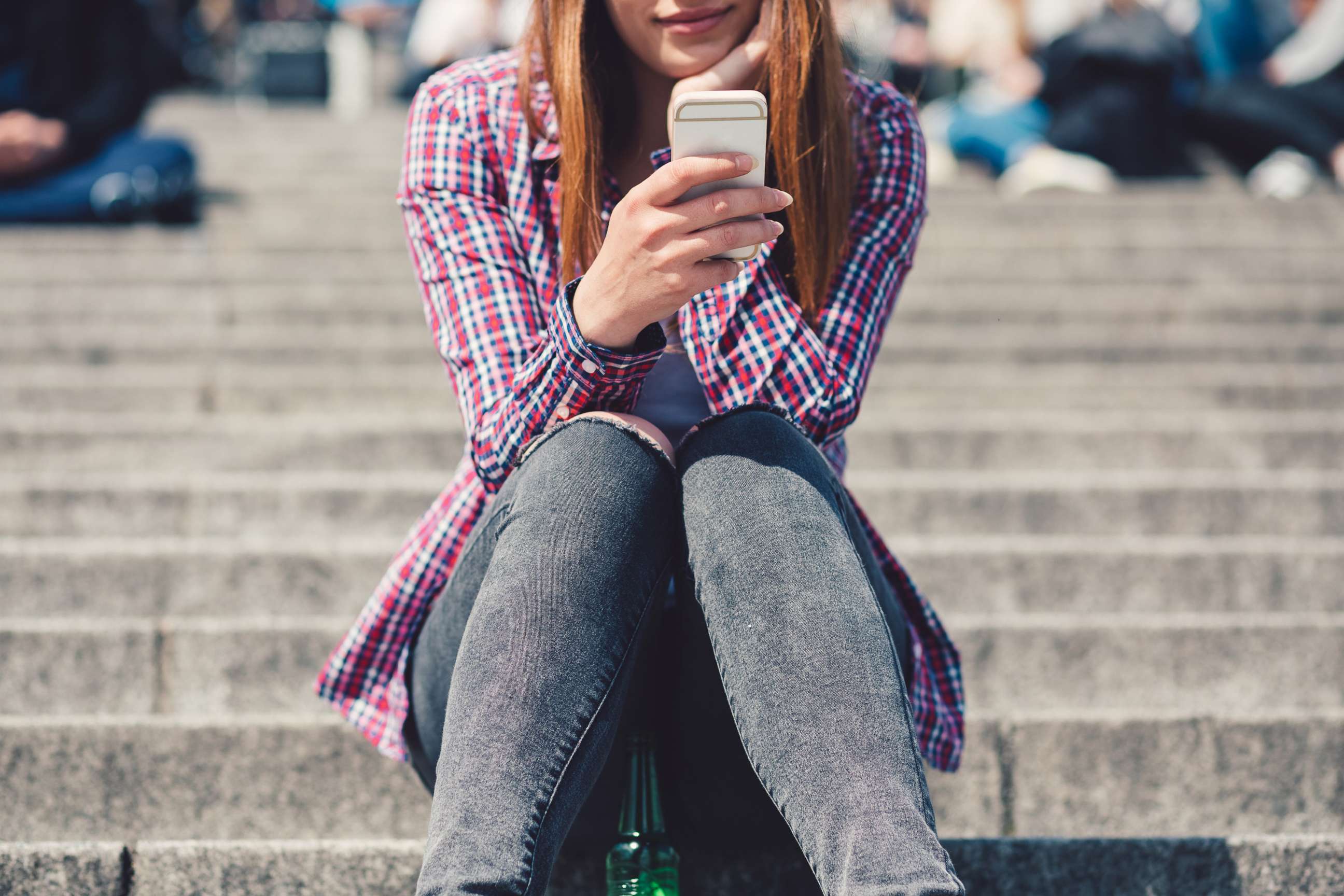 PHOTO: A young woman uses a smartphone in an undated stock photo. 