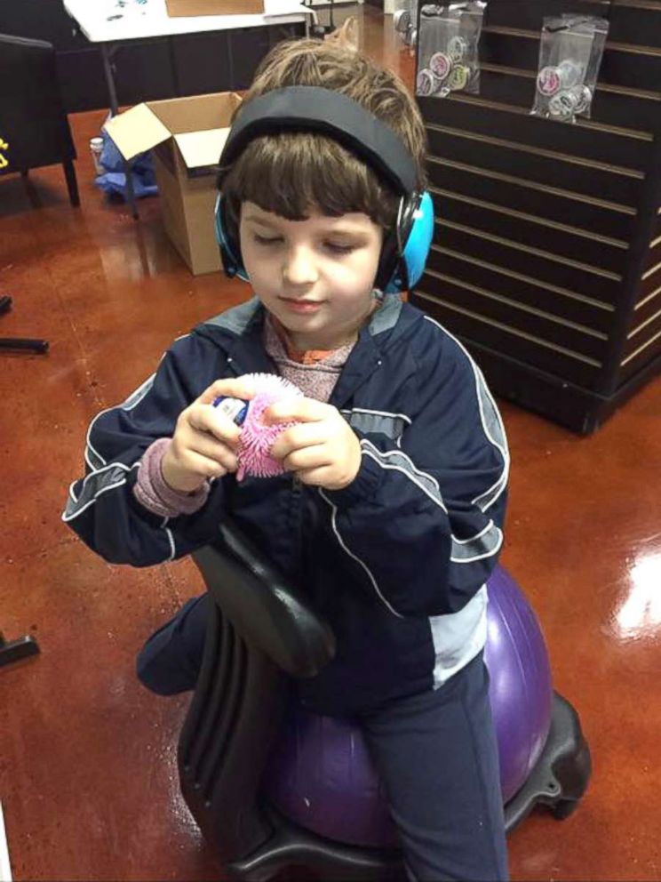 PHOTO: Roman Young, 8, seen playing with a sensory item inside his mother's Ohio store, Puzzle Pieces. 
