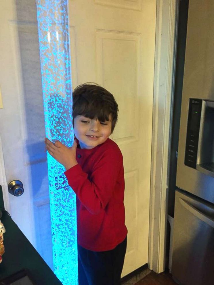 PHOTO: Roman Young, 8, seen interacting with a sensory item inside his mother's Ohio store, Puzzle Pieces. 