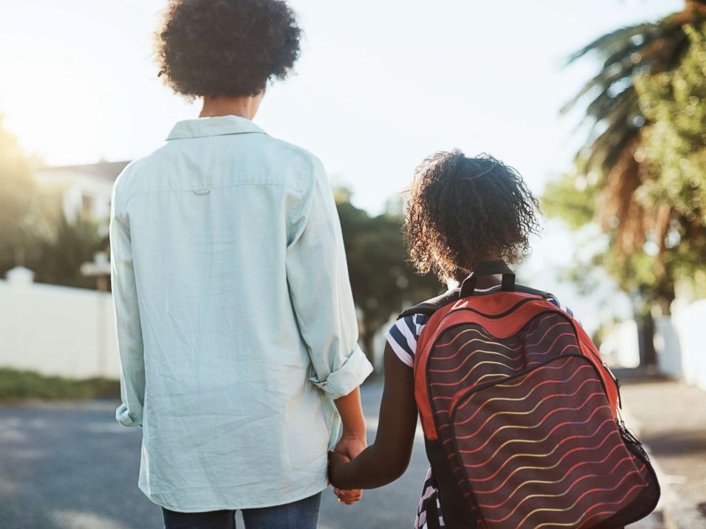 PHOTO: Young mother and daughter holding hands.