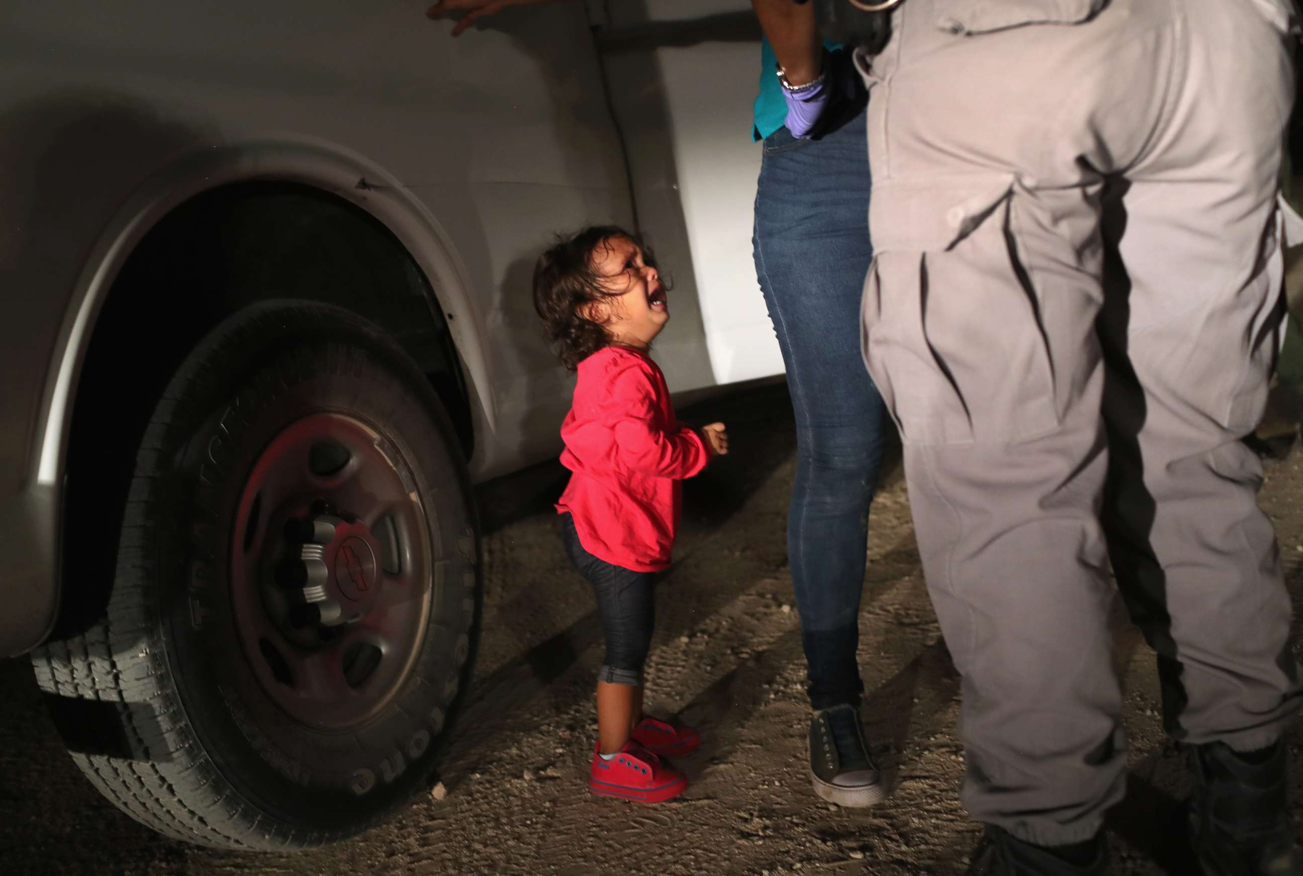 PHOTO: A two-year-old Honduran asylum seeker cries as her mother is searched and detained near the U.S.-Mexico border on June 12, 2018, in McAllen, Texas. 