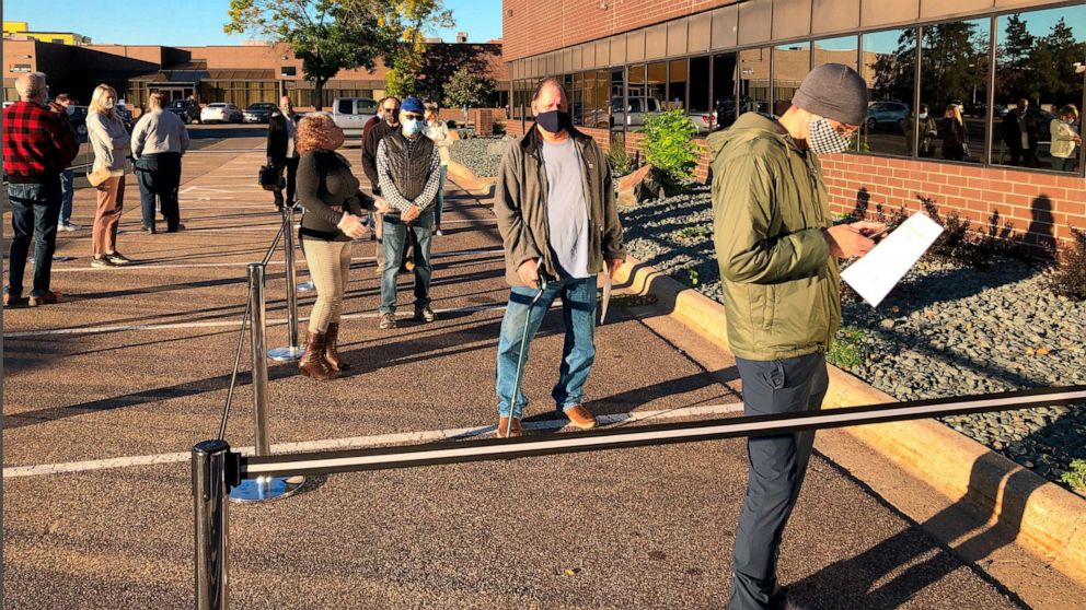 PHOTO: Voters line up outside of an early voting center in Minneapolis, Sept. 18, 2020.