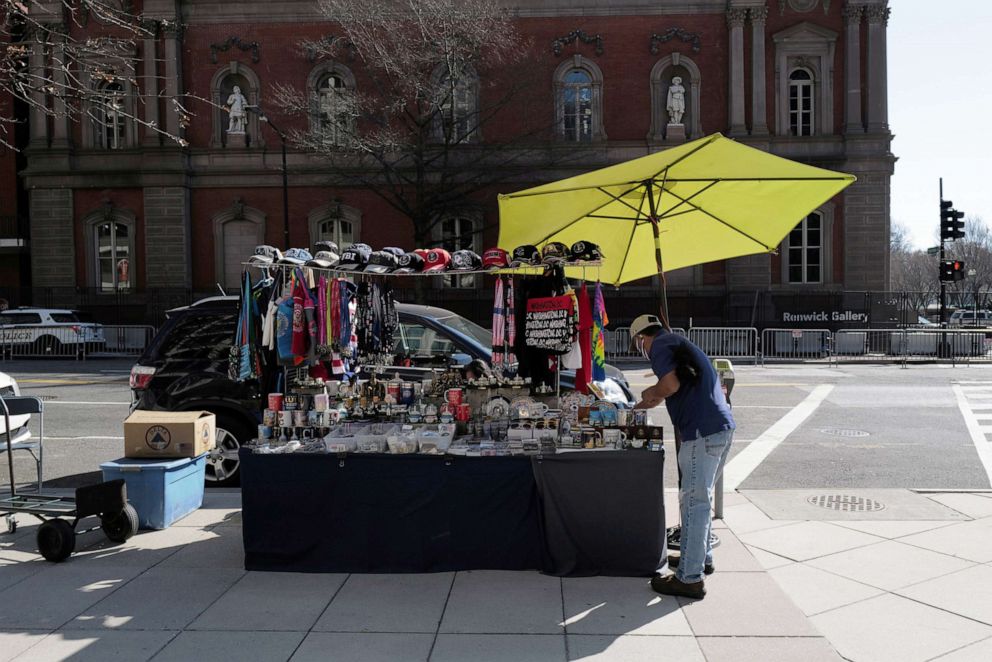 PHOTO: A street vendor sets up his booth near the White House, as more streets have been opened back after lifting some of the security measures, in Washington, D.C., March 14, 2021.