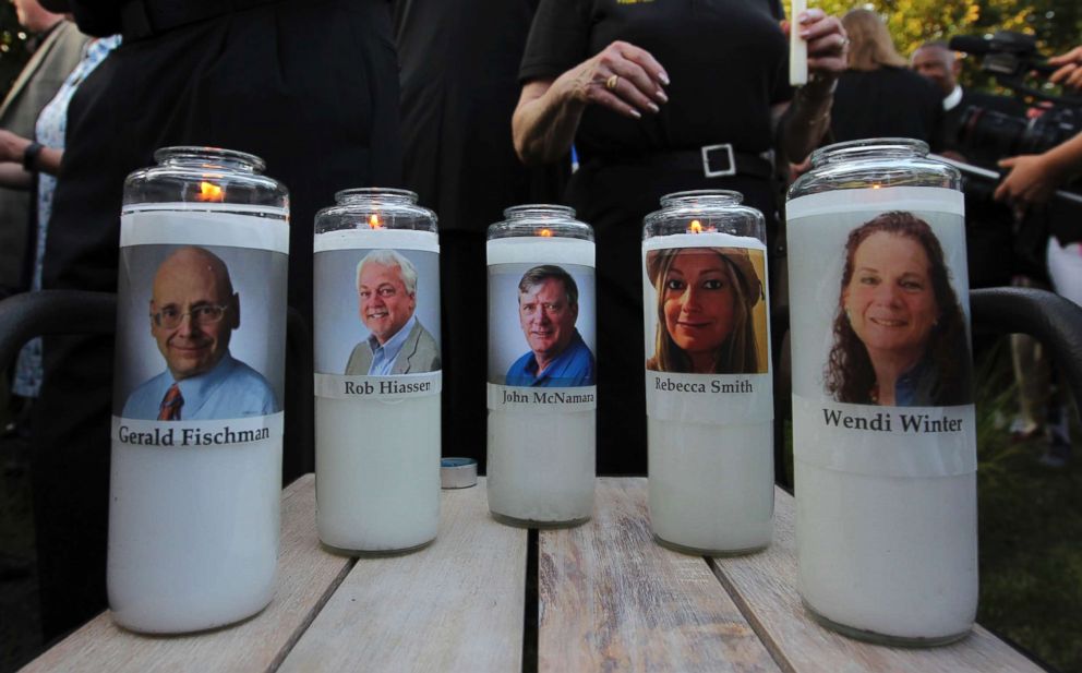 PHOTO: Photos of five journalists adorn candles during a vigil across the street from where they were slain in their newsroom in Annapolis, Md., June 29, 2018.
