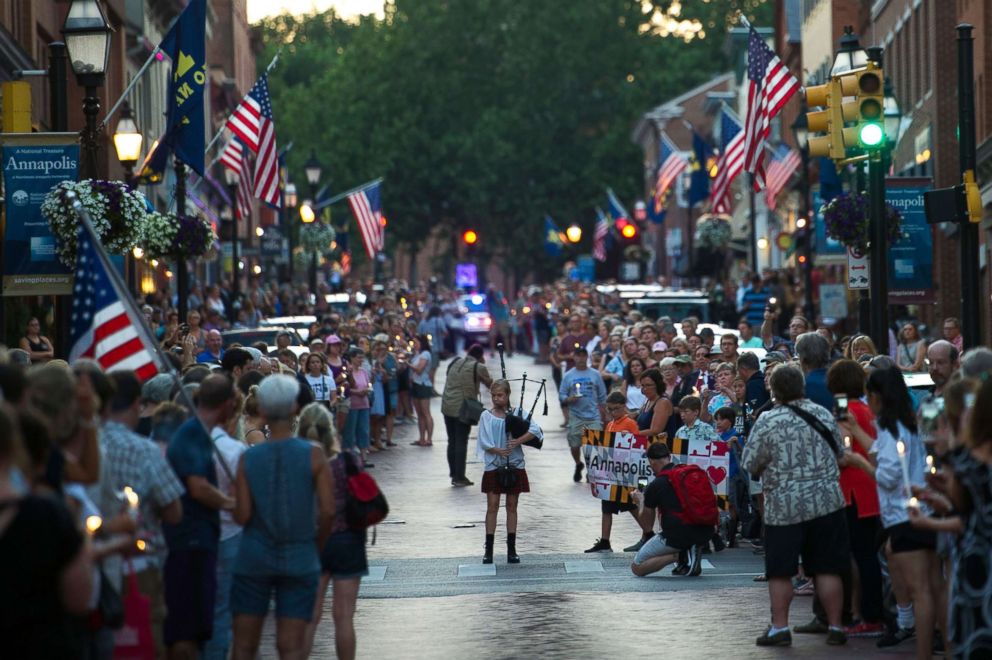 PHOTO: Mackenzie Bought, 16, plays 'Amazing Grace' on the bag pipes as thousands of people march during a candle light vigil to remember the five journalists from The Capital Gazette newspaper in Annapolis, Maryland, June 29, 2018.