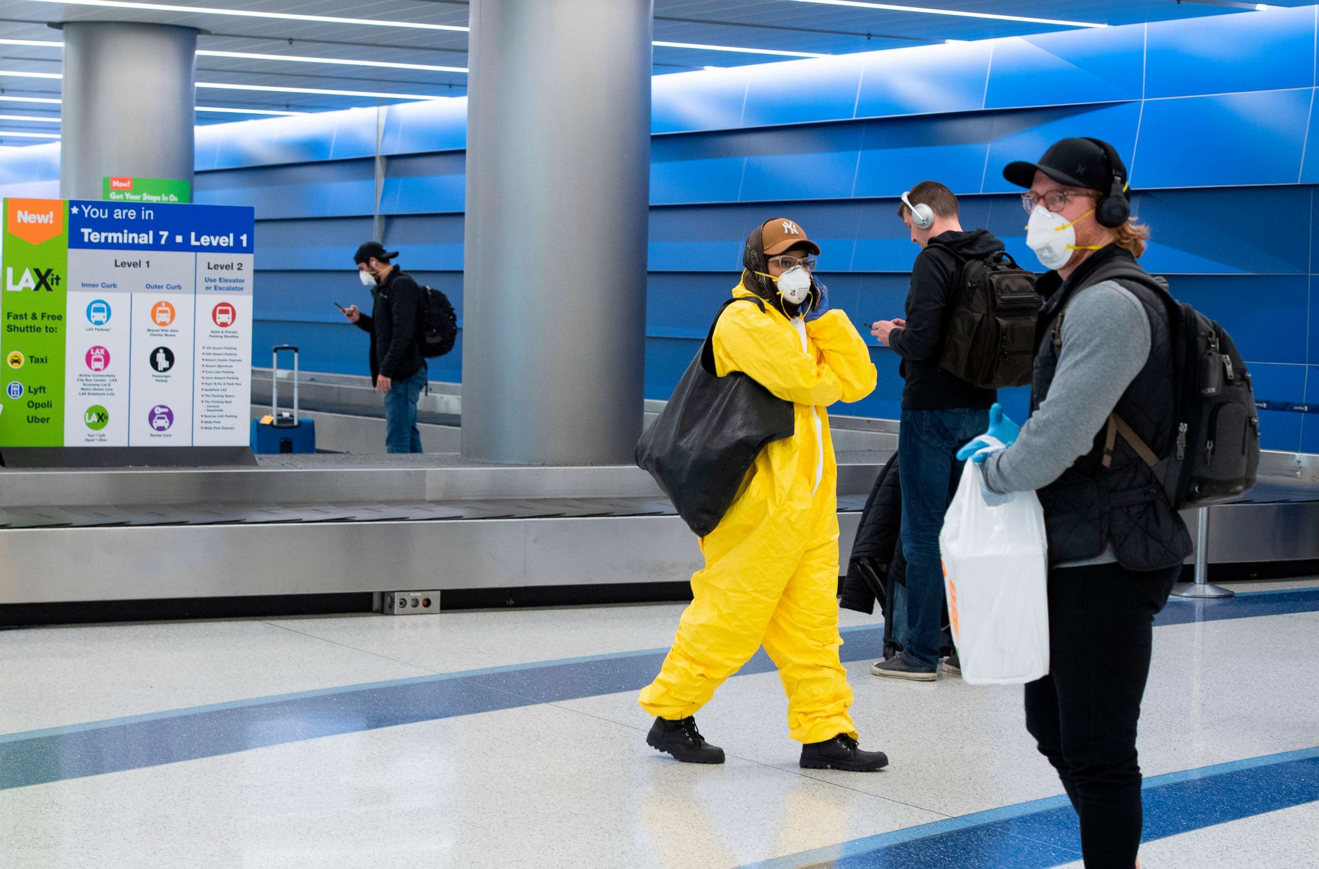 PHOTO: A person wearing plastic coveralls and mask waits for their luggage at Terminal 7 at Los Angeles International Airport (LAX) during the outbreak of the novel coronavirus, which causes COVID-19, April 16, 2020, in Los Angeles.