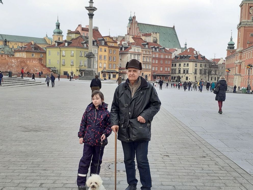 PHOTO: Valeriy Zharkovska stands with his granddaughter in a pedestrian street in Warsaw after fleeing the explosions in his hometown of Kharkiv, Ukraine's second largest city.