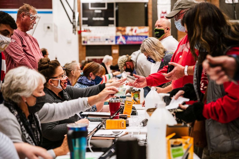 PHOTO: Voters check in with election officials before receiving their ballots at Ballard High School on Nov. 3, 2020 in Louisville, Ky.
