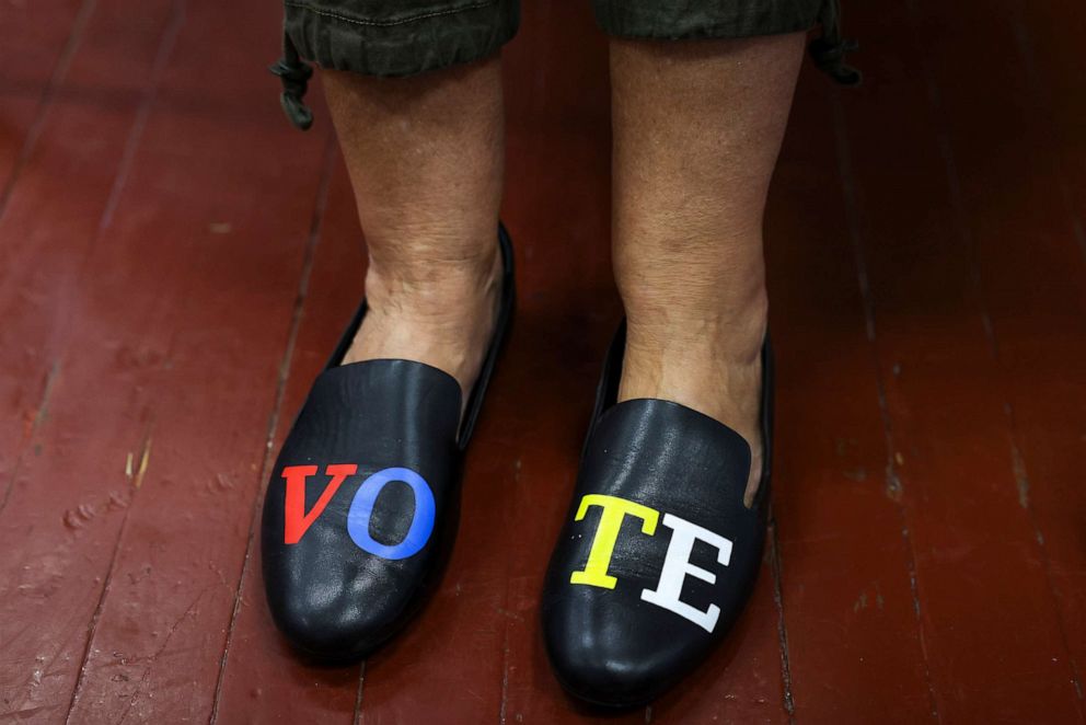 PHOTO: Poll manager Susan Taylor wears shoes with the word "Vote" as she checks people in to vote at the Hazel Parker Playground on Election Day in Charleston, N.C., Nov. 3, 2020.