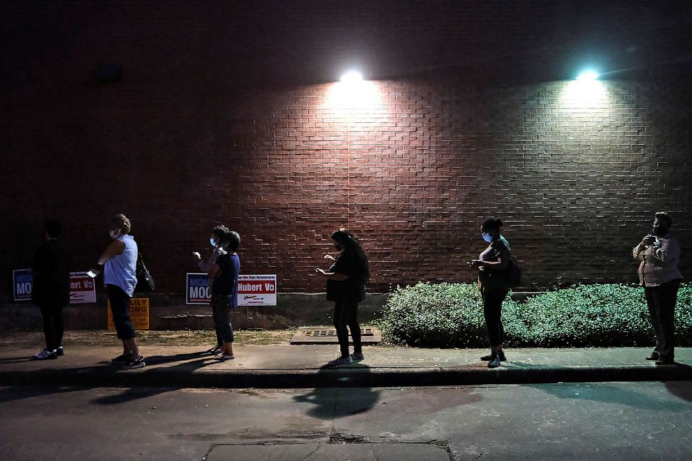 PHOTO: People wait in line to cast their ballots for the presidential election as early voting begins in Houston, Oct. 13, 2020.