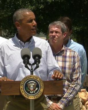 The president toured a flooded neighborhood before pledging federal assistance.