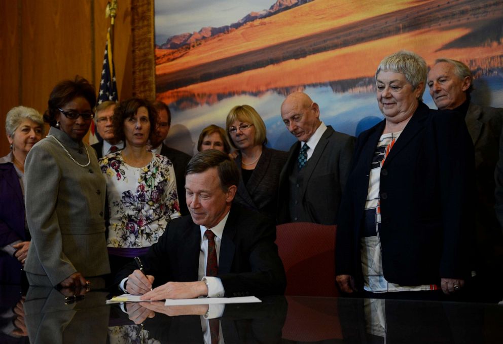 PHOTO: Colorado Governor John Hickenlooper signs three gun control measures in his office at the state capitol, March, 20, 2013.