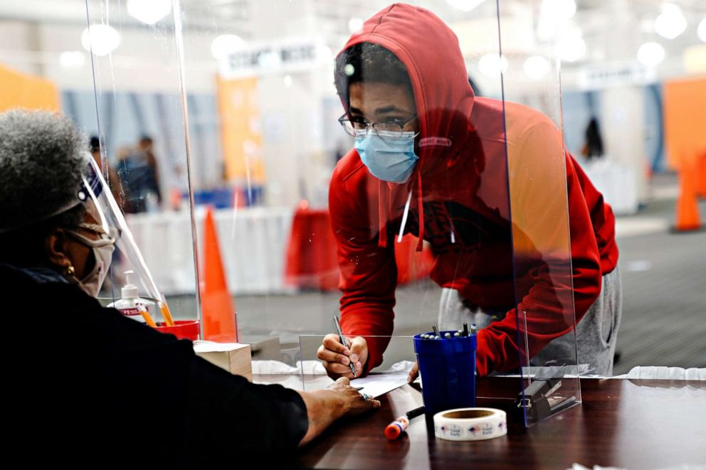 PHOTO: A young voter fills out a ballot with assistance from a poll worker at a polling station at the Midtown Center shopping mall in Milwaukee on the first day of in-person voting in Wisconsin, Oct. 20, 2020.