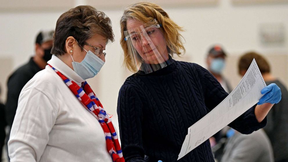 PHOTO: Poll workers Cheryl Hicks and Karen Rearick examine a precinct specific ballot inside the First United Methodist Church, Tuesday, Nov. 3, 2020, in New Philadelphia, Ohio.