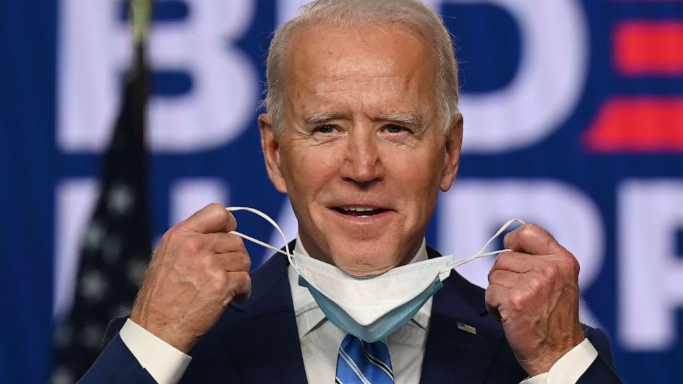 PHOTO: Democratic Presidential candidate Joe Biden removes his mask before speaking at the Chase Center in Wilmington, Del., Nov. 4, 2020.