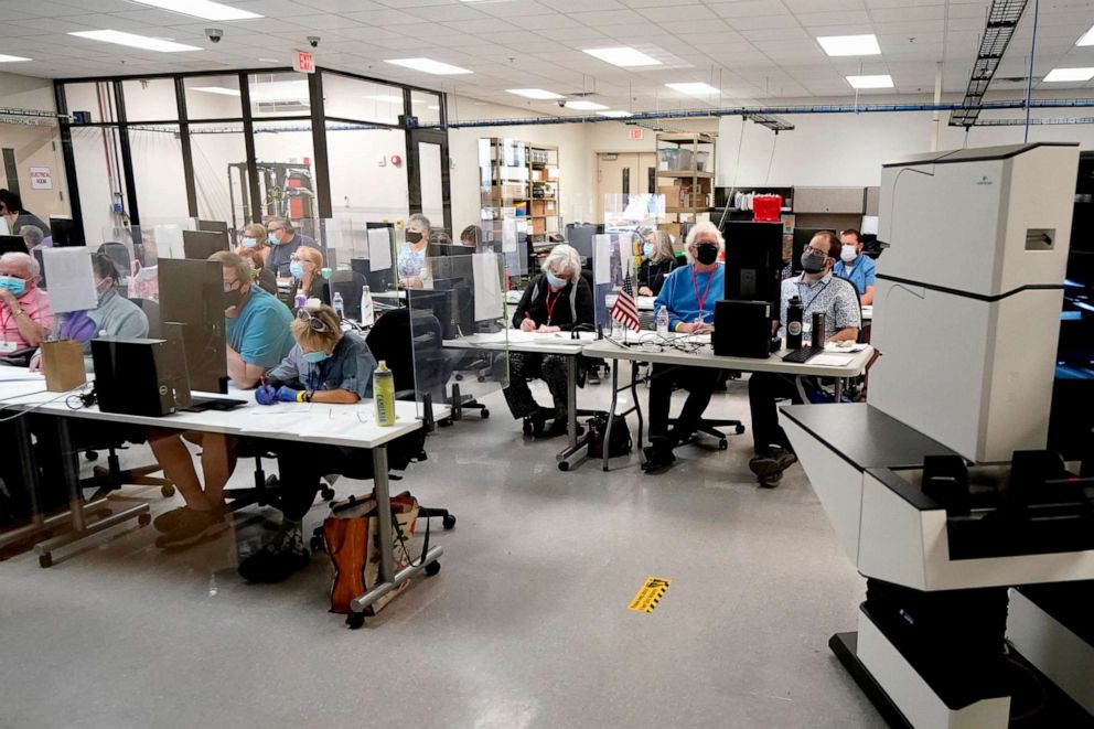 PHOTO: Maricopa County elections officials and observers watch as ballots are tallied, Wednesday, Nov. 4, 2020, at the Maricopa County Recorders Office in Phoenix.