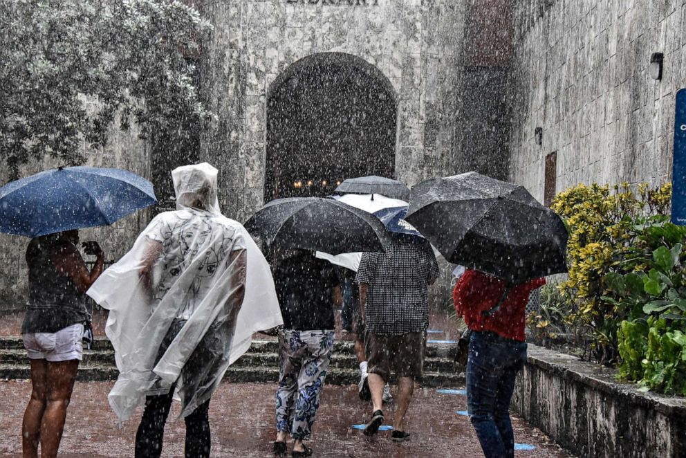 PHOTO: People wait on line during a heavy rain to cast their votes on the second day of early voting, Oct, 20, 2020, in Miami.