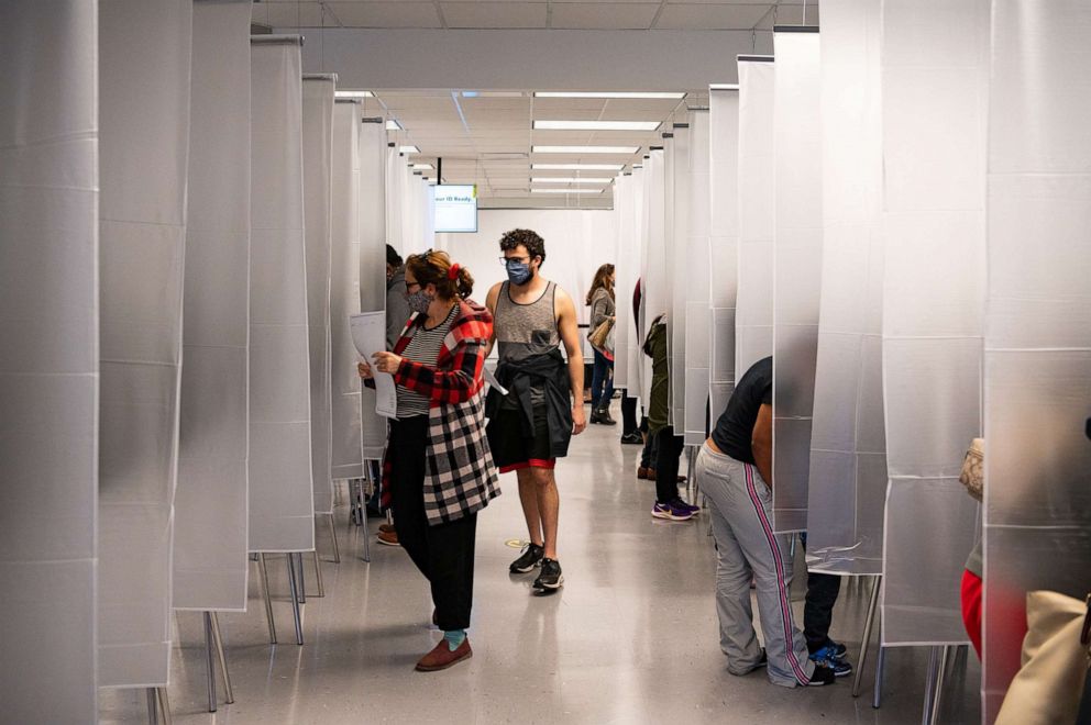 PHOTO: Residents of Cuyahoga county, separated by plastic due to health concerns amid the coronavirus pandemic, arrive to fill out paper ballots for early, in-person voting at the board of elections office in Cleveland on Oct. 16, 2020.