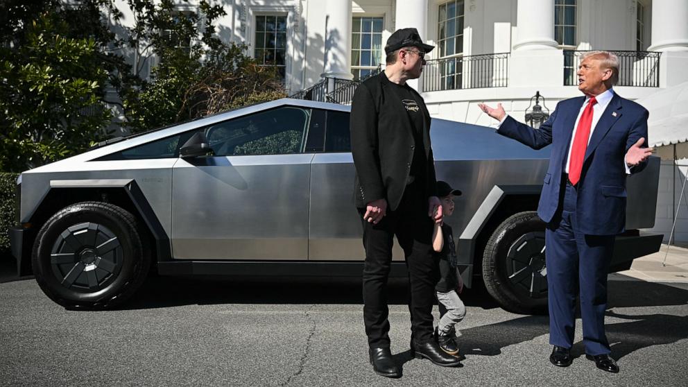 PHOTO: President Donald Trump and Tesla CEO Elon Musk speak to the press as they stand next to a Tesla Cybertruck on the South Portico of the White House, on March 11, 2025, in Washington, D.C.