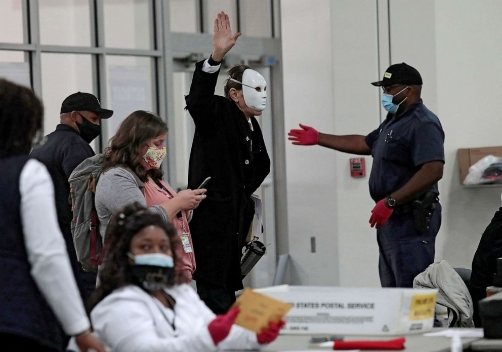 PHOTO: A poll challenger wearing a full face mask is removed by Detroit Police for causing a disturbance during absentee ballot processing at the TCF Center in Detroit, Nov. 2, 2020.
