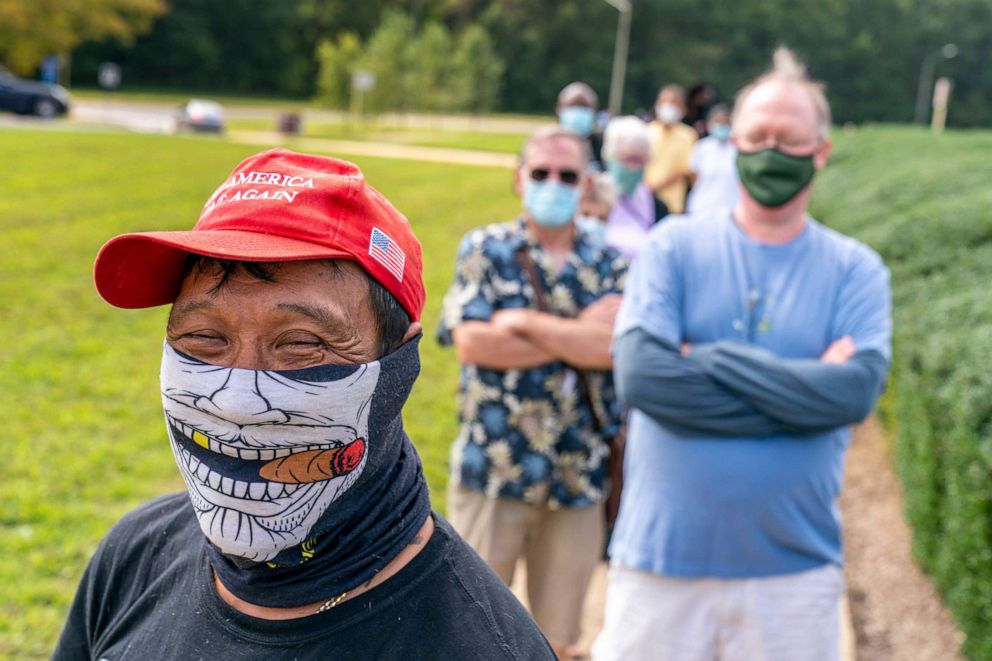 PHOTO: Kin Lee of Alexandria, Va., wearing a pro-Trump hat and shirt, waits in a line for early voting at Fairfax County Government Center, in Fairfax, Va., Sept. 18, 2020.