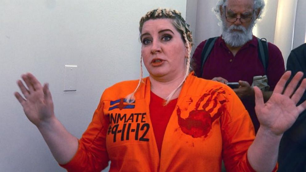 Diane Atkins came all the way from Brooklyn, NY, dressed in an orange jumpsuit with the words "INMATE 9-11-12" and a print of a bloody hand to try to get in the Benghazi hearing room to taunt Hillary Clinton, on Oct. 22, 2015.