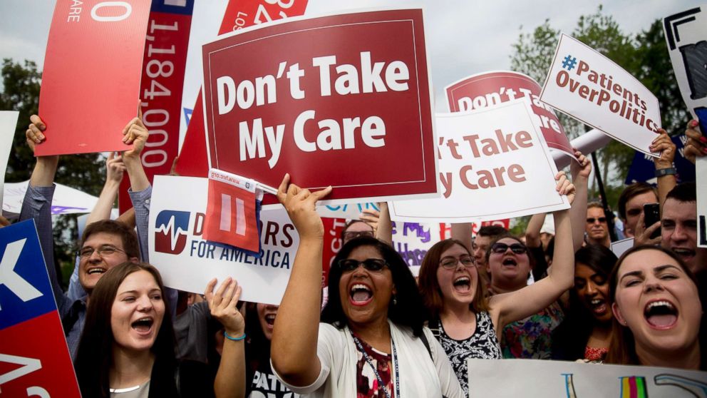 Demonstrators in support of former President Barack Obama's health-care law, the Affordable Care Act (ACA), cheer while holding up signs after the U.S. Supreme Court ruled 6-3 to save Obamacare tax subsidies outside the Supreme Court in Washington, D.C. on June 25, 2015.