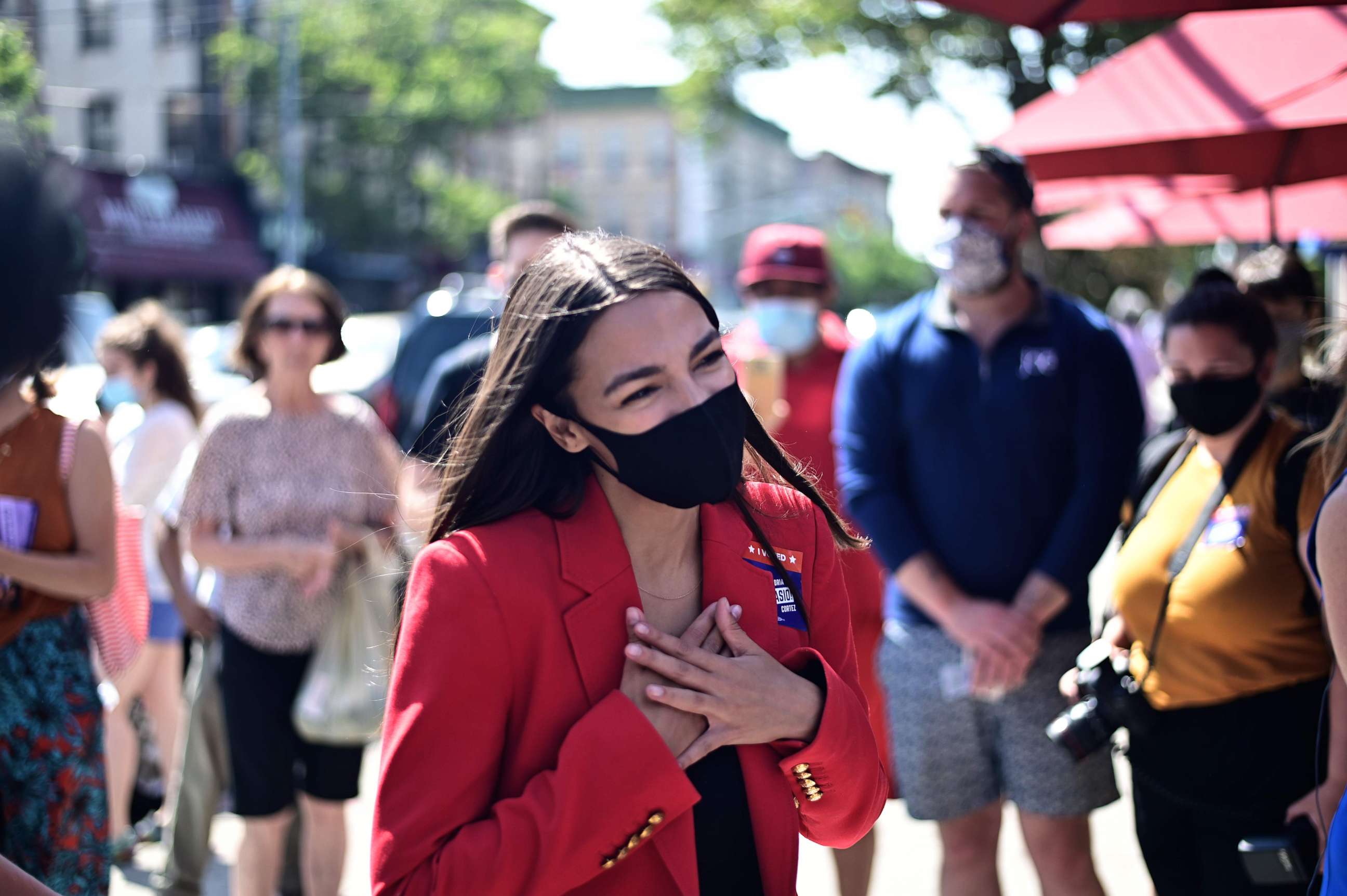 PHOTO: (FILES) In this file photo taken on June 23, 2020 US Representative Alexandria Ocasio-Cortez (D-NY), speaks with a voter near a polling station during the New York primaries Election Day  in New York City.