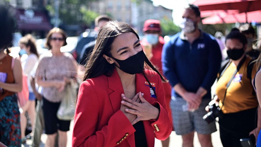 PHOTO: (FILES) In this file photo taken on June 23, 2020 US Representative Alexandria Ocasio-Cortez (D-NY), speaks with a voter near a polling station during the New York primaries Election Day in New York City.