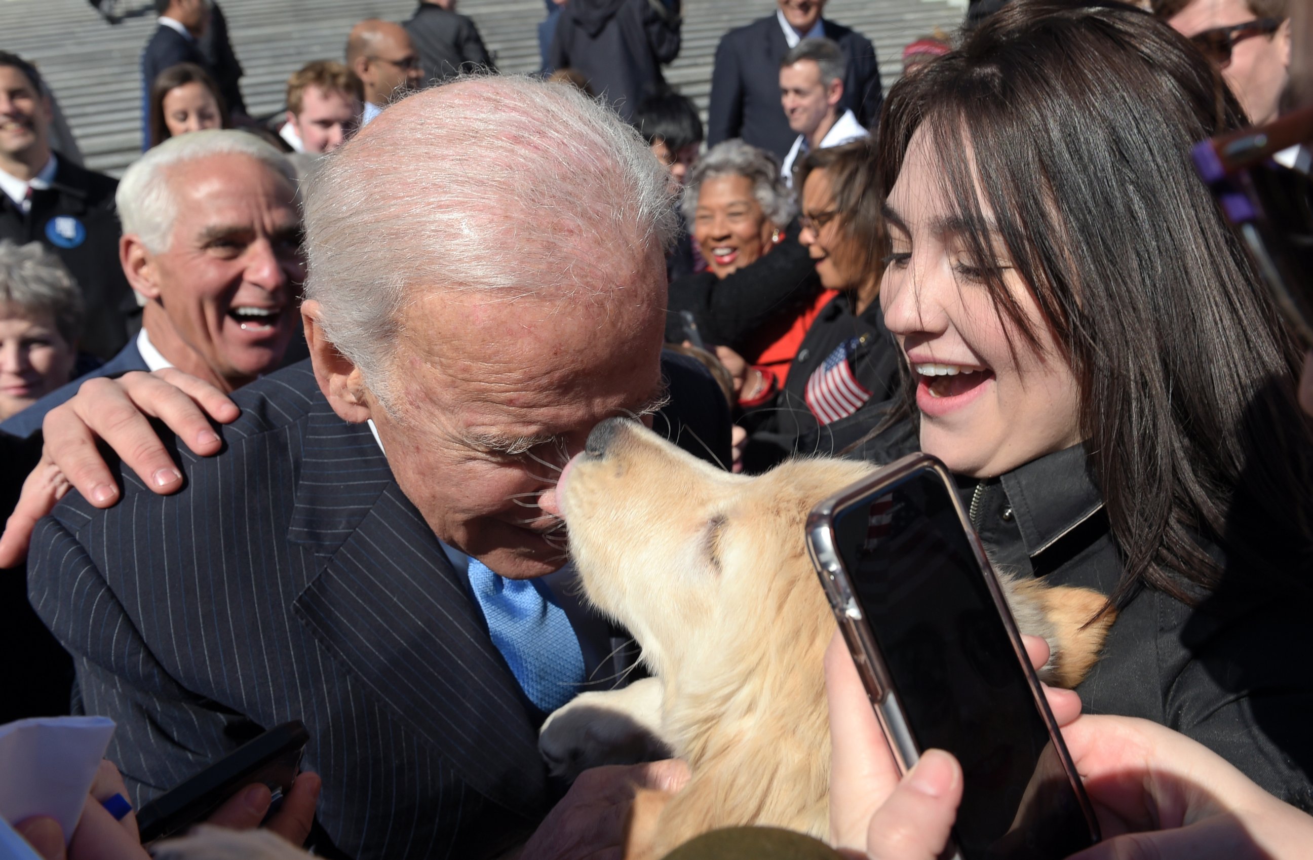 PHOTO: Former Vice President Joe Biden gets a kiss from a dog as he greets the crowd on Capitol Hill in Washington, March 22, 2017, following an event marking seven years since former President Barack Obama signed the Affordable Care Act into law. 