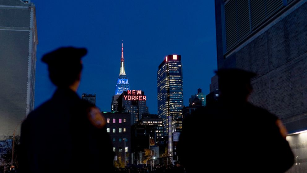 PHOTO: The city skyline with the Empire State Building lit in red, white and blue, rises over police officers near the Jacob Javits Center where Democratic presidential candidate Hillary Clinton will hold a rally in New York, Nov. 8, 2016.