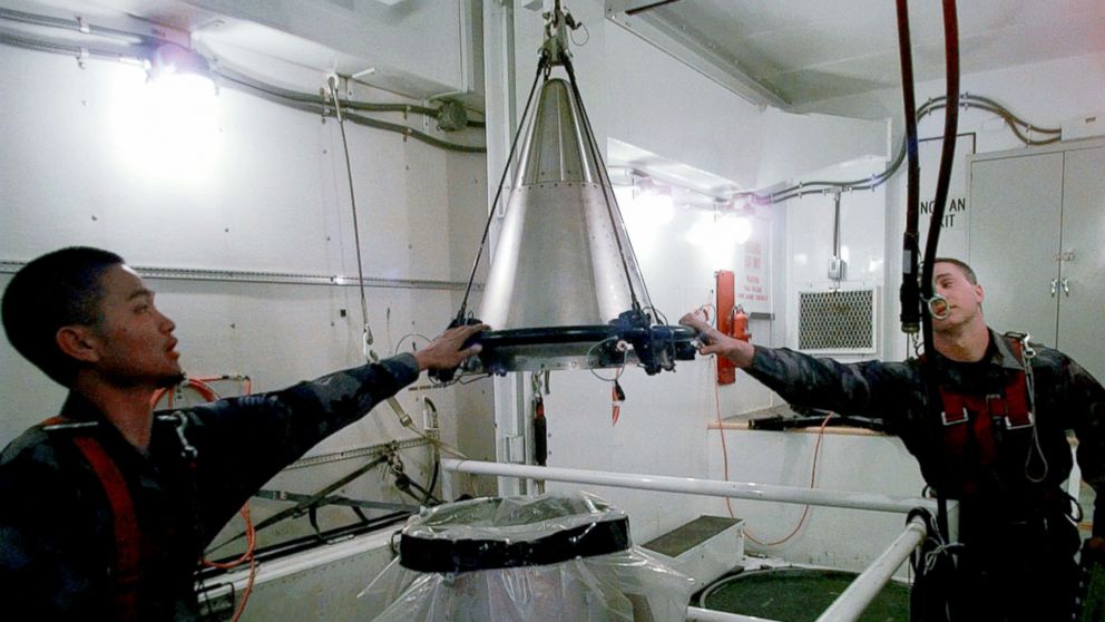 Senior Airmen Mark Pacis, left, and Christopher Carver mount a refurbished nuclear warhead on to the top of a Minuteman III intercontinental ballistic missile inside an underground silo in Scottsbluff, Neb., April 15, 1997.