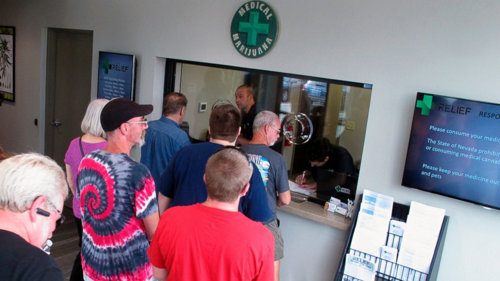 People line up to be among the first in Nevada to legally purchase medical marijuana at the Silver State Relief dispensary in Sparks, Nev., July 31, 2015. Nevada's marijuana regulators are working furiously to launch recreational sales on July 1, a fast-approaching deadline that could hinge on a court deciding whether the powerful liquor industry should be guaranteed a piece of the pot pie before tourists and residents can light up. 