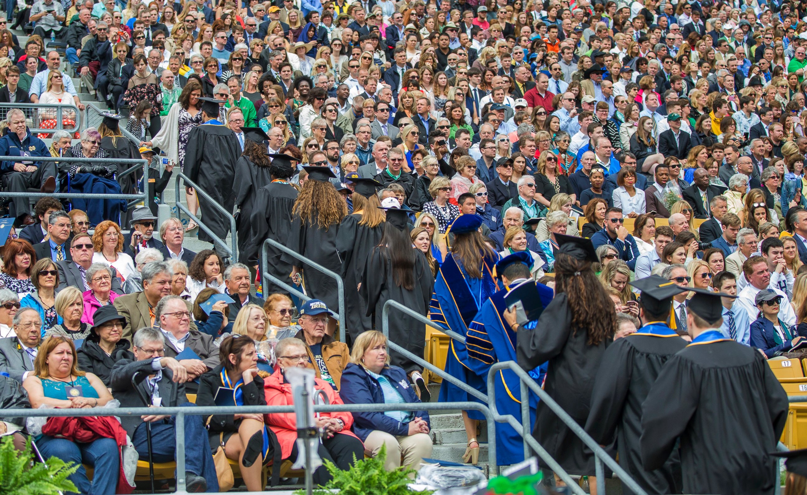 PHOTO: Notre Dame graduates walk out of Notre Dame Stadium in protest as Vice President Mike Pence speaks during the 2017 commencement ceremony, May 21, 2017, in South Bend, Ind. 