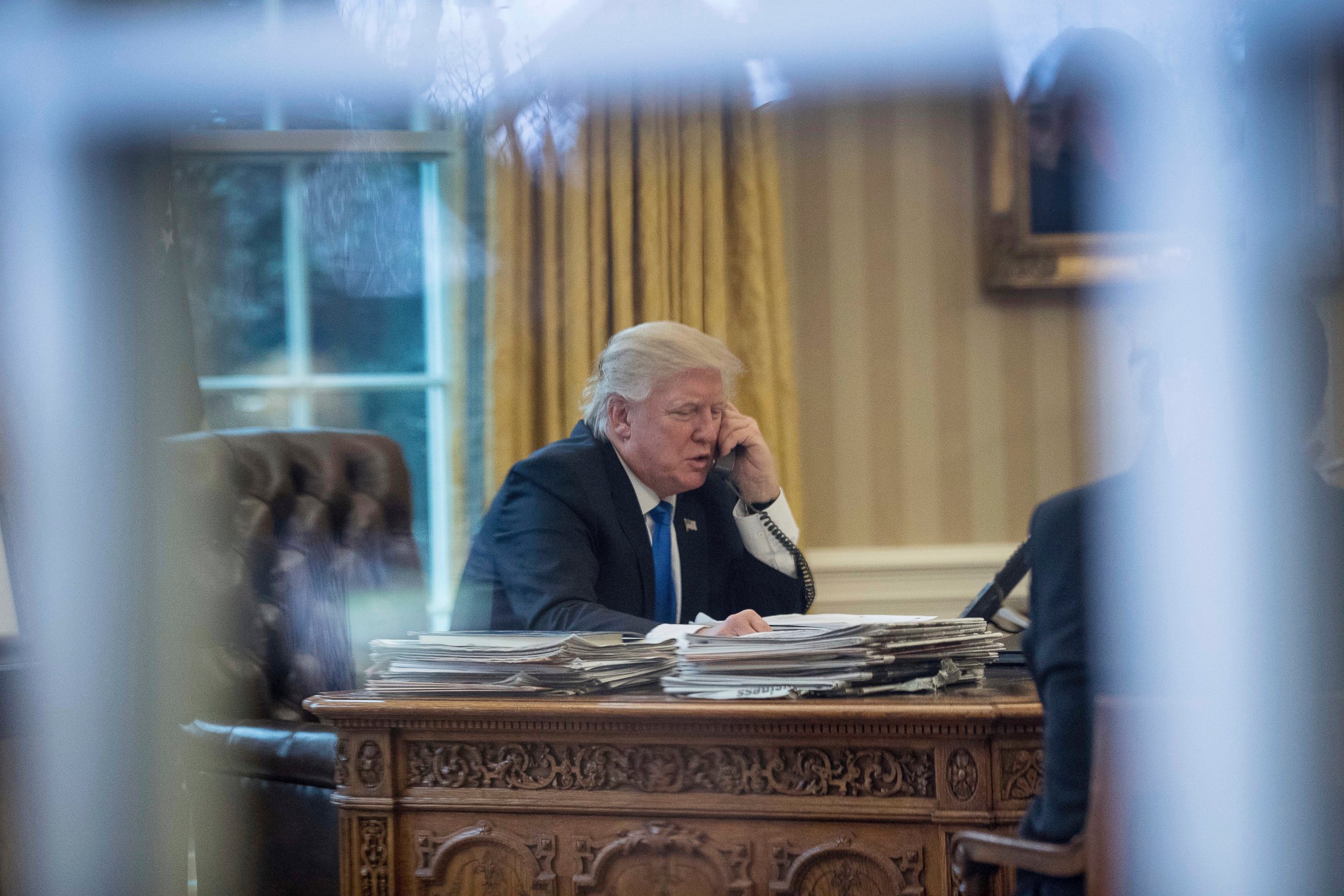 PHOTO: President Donald Trump speaks on the phone with German Chancellor Angela Merkel, Jan. 28, 2017, in the Oval Office at the White House in Washington.