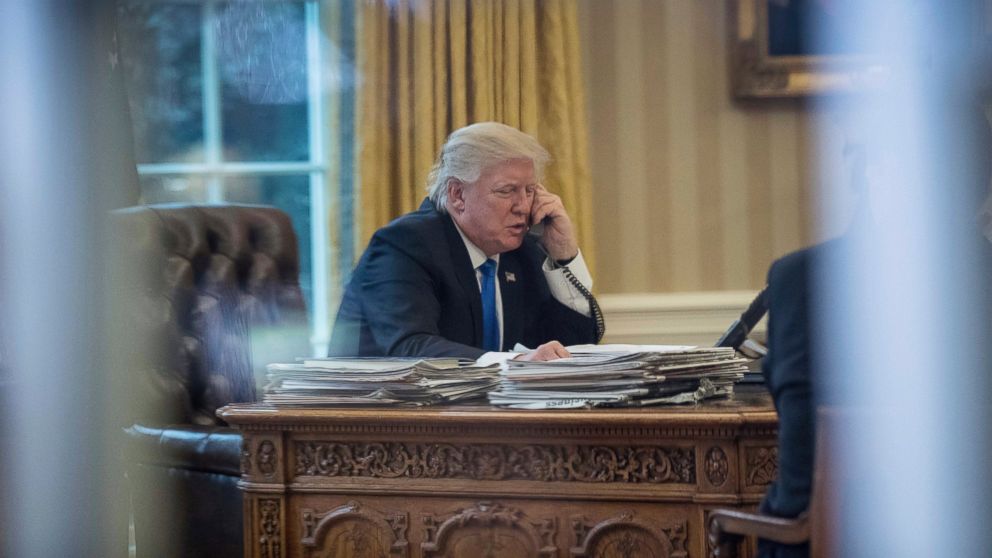 President Donald Trump speaks on the phone with German Chancellor Angela Merkel, Jan. 28, 2017, in the Oval Office at the White House in Washington.