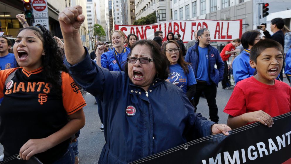 Guadalupe Chavez, center, and others yell during a protest outside of the U.S. Citizen and Immigration Services building in San Francisco, May 1, 2017.