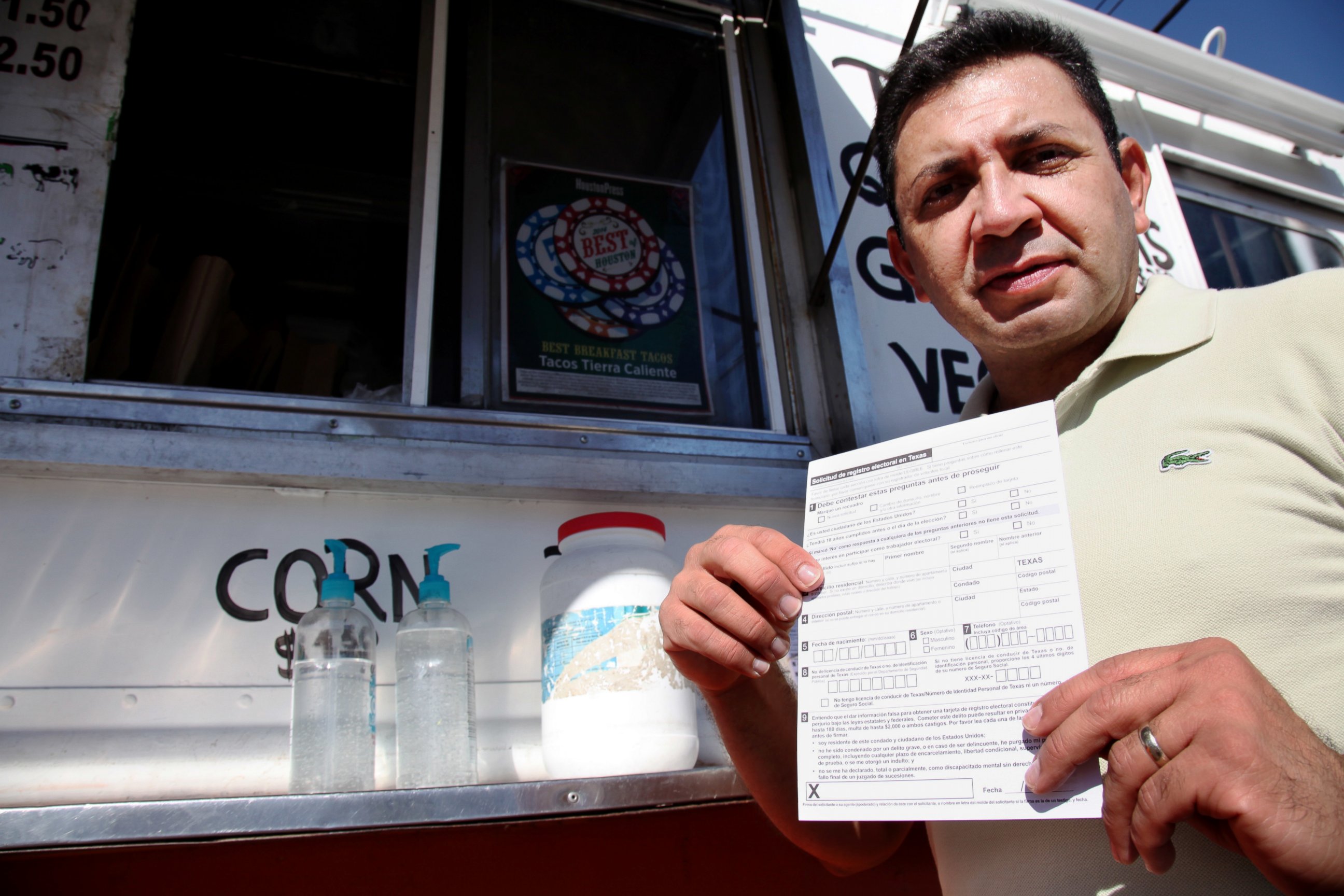 PHOTO: Carlos Zamora shows a voter registration card from a pile placed on the counter of the Tierra Caliente taco truck in this Sept. 29, 2016 image in Houston.