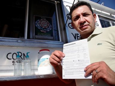 PHOTO: Carlos Zamora shows a voter registration card from a pile placed on the counter of the Tierra Caliente taco truck in this Sept. 29, 2016 image in Houston.