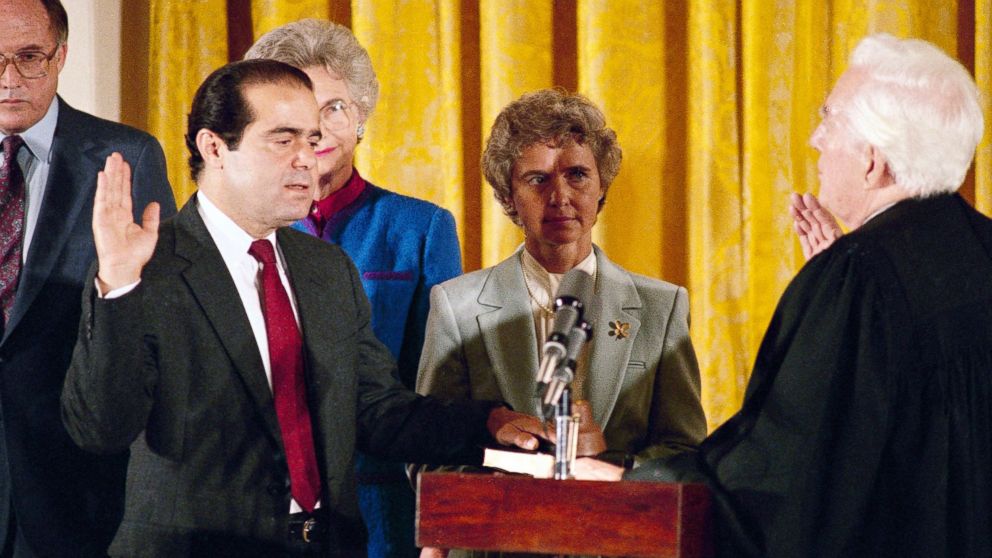 FILE - In this Friday, Sept. 26, 1986 file photo, retiring Chief Justice Warren Burger, right, administers an oath to Associate Justice Antonin Scalia, as Scalia's wife, Maureen, holds the bible during ceremonies in the East Room of White House, Washington. Scalia was the 103rd person to sit on the court. On Saturday, Feb. 13, 2016, the U.S. Marshals Service confirmed that Scalia has died at the age of 79. 