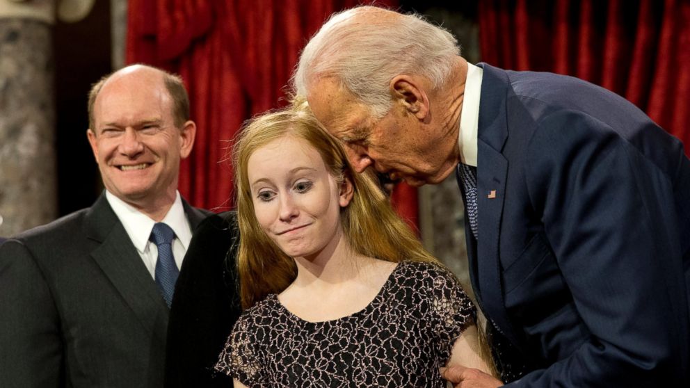 Vice President Joe Biden leans in to say something to Maggie Coons, next to her father Sen. Chris Coons, D-Del., after Biden administered the Senate oath to Coons during a ceremonial re-enactment swearing-in ceremony, Tuesday, Jan. 6, 2015, in the Old Senate Chamber of Capitol Hill in Washington. 