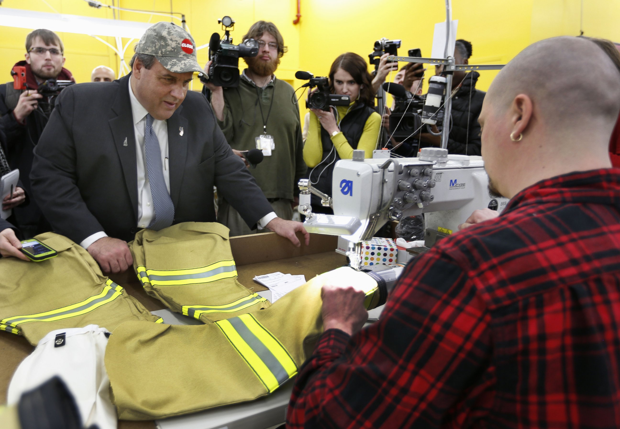 PHOTO: Republican presidential candidate, New Jersey Gov.Chris Christie watches as Tom Carr sews sleeves on a firefighter suit during a campaign stop at Globe Manufacturing, Jan. 21, 2016, in Pittsfield, N.H.