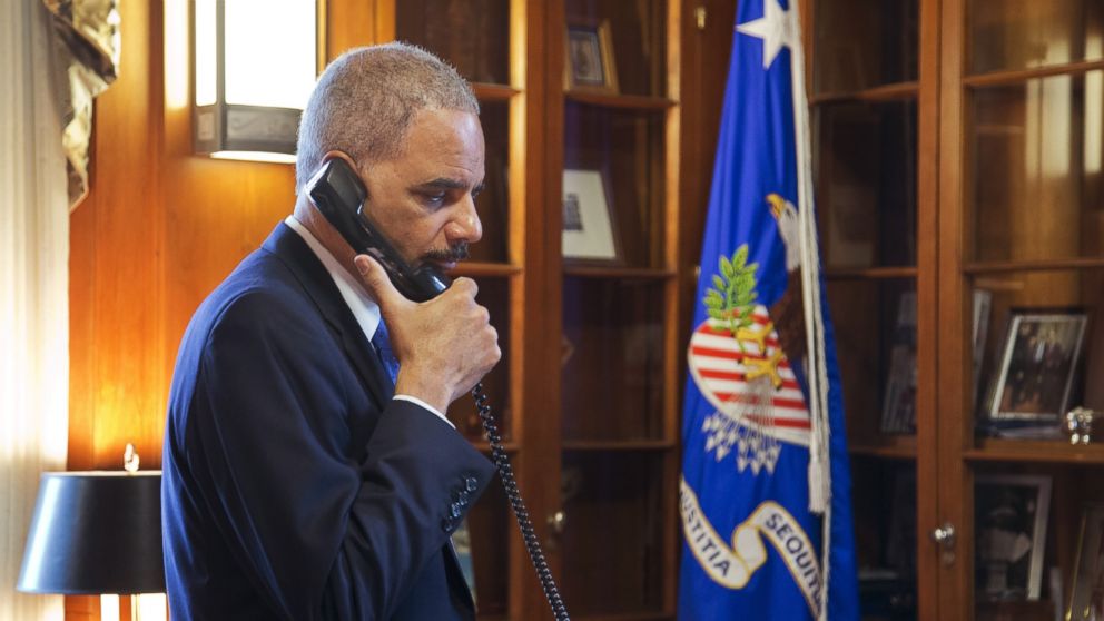 Attorney General Eric Holder makes calls related to the situation in Ferguson in his office at the Department of Justice in Washington, Nov. 25, 2014. 