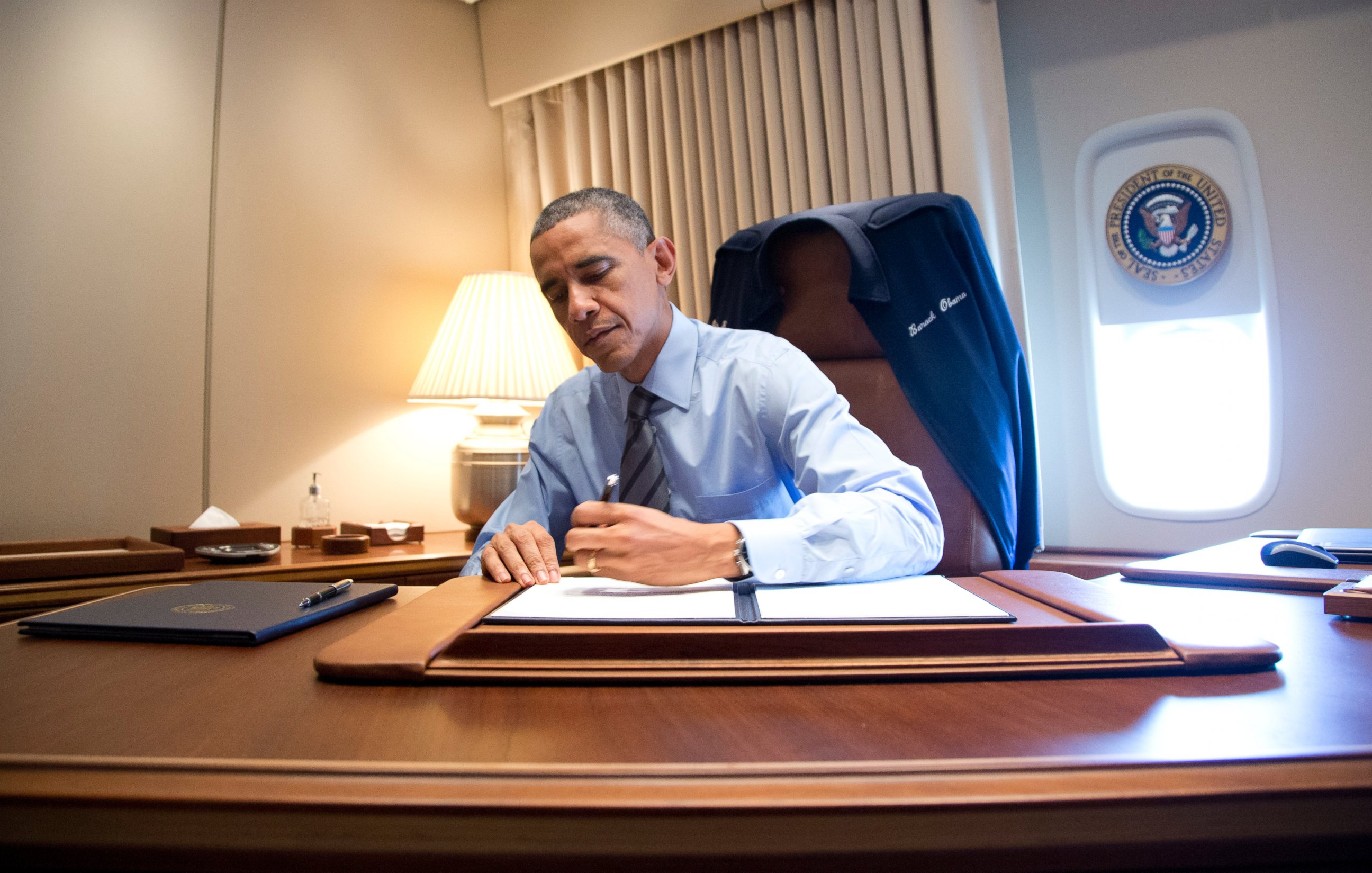 PHOTO: President Barack Obama signs two presidential memoranda associated with his actions on immigration in his office on Air Force One as he arrives at McCarran International Airport in Las Vegas on Nov. 21, 2014. 