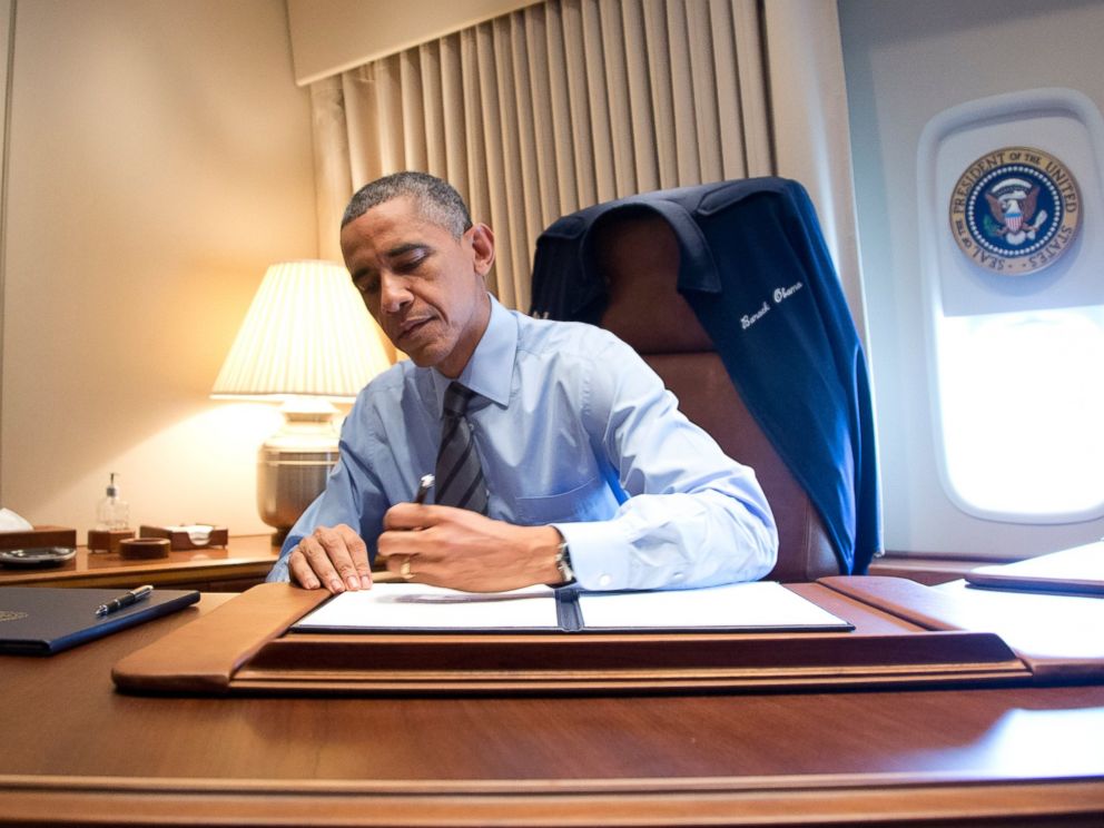 PHOTO: President Barack Obama signs two presidential memoranda associated with his actions on immigration in his office on Air Force One as he arrives at McCarran International Airport in Las Vegas on Nov. 21, 2014.